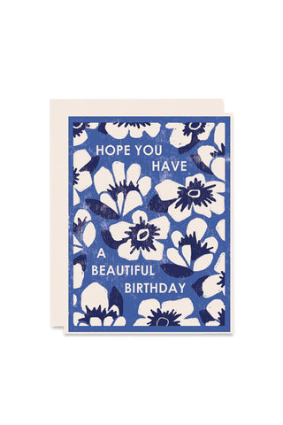 Floral birthday card with blue and white flowers and text that reads "Hope you have a beautiful birthday" on a white background