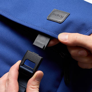 Person closing messenger bag with buckle closure 