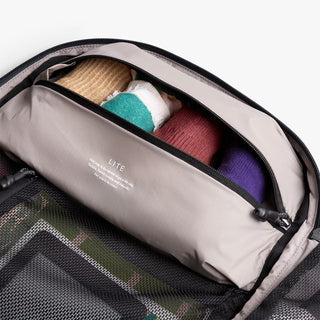Open backpack with socks inside on a neutral background