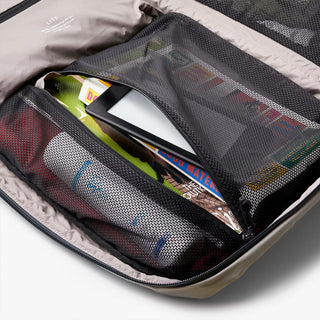 Open backpack with travel items in a mesh compartment