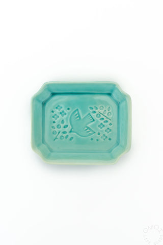 Teal ceramic tray with decorative bird and orchid design on a white background