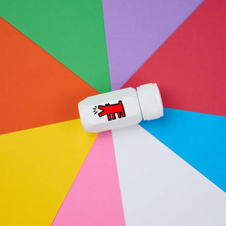 White pencil sharpener with a red and black dog illustration on a colorful geometric background