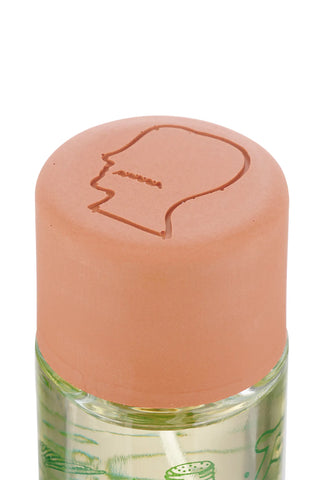 Small bottle with a peach-colored cap featuring a face design on a white background