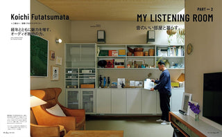 Living room with shelves, furniture, and a person holding a record