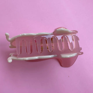 Pink hair clip on a pink background