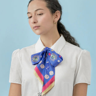 Person wearing a colorful scarf with good luck symbols on a light blue background
