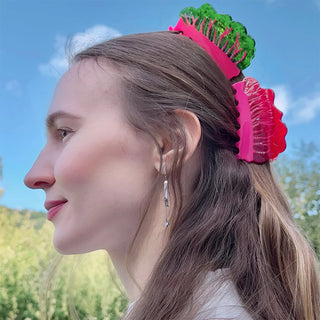 Person wearing two chard shaped hairclips outside