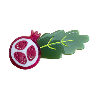 Pomegranate-shaped hair clip with a green leaf on a white background