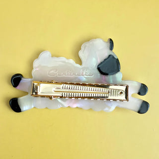 Back of sheep hair clip to show teeth of hair clip on a yellow background