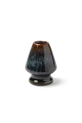 Black and brown ceramic whisk stand on a white background