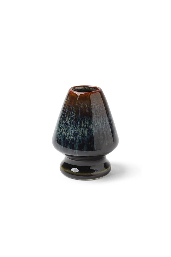 Black and brown ceramic whisk stand on a white background