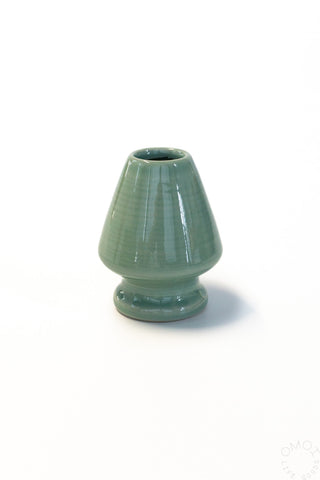 Green ceramic whisk stand on a white background