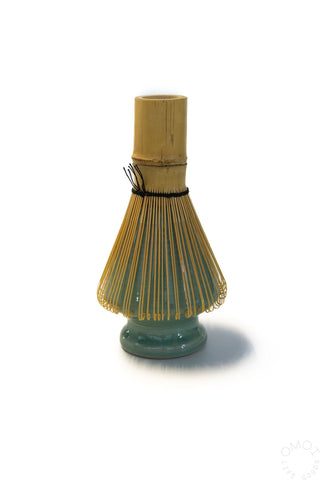 Bamboo whisk with green ceramic base on a white background