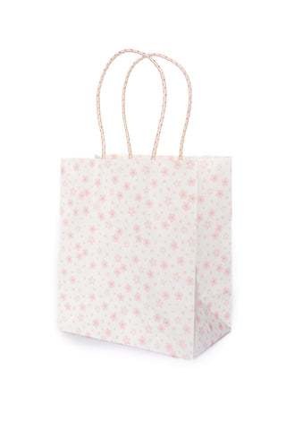 White paper gift bag with pink floral pattern and handle on a white background