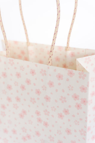 Close up of gift bag with pink floral pattern on a white background