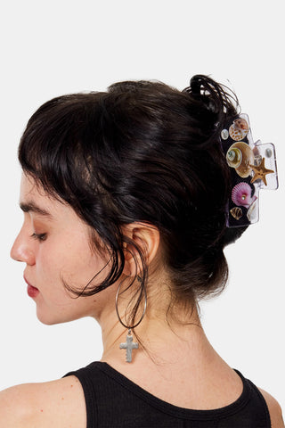 Woman with decorative hair clip and black tank top on a white background