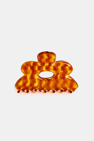 Orange and brown checkered hair clip on a white background