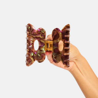 Person holding open colorful hair clip