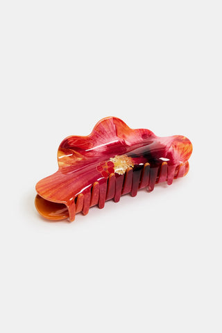 Red hibiscus patterned hair clip on a white background