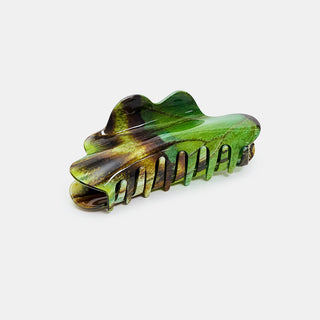 Green and brown claw hair clip against a white background