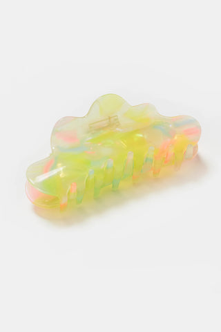 Multicolor claw hair clip with yellow, pink, and blue hues on a light background