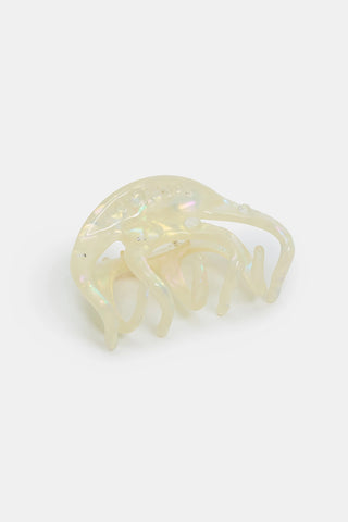 A translucent iridescent cream claw hair clip on a white background.