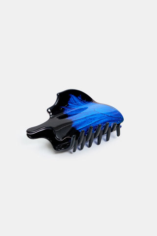 A hair claw clip with a black and vibrant blue swallowtail butterfly pattern against a white background