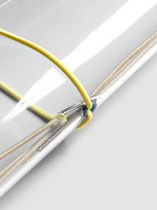 Close-up: yellow and beige elastic bands on silver-ring travel cover