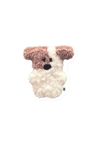 Clear sticker of a plush dog toy with brown and white fur on a white background