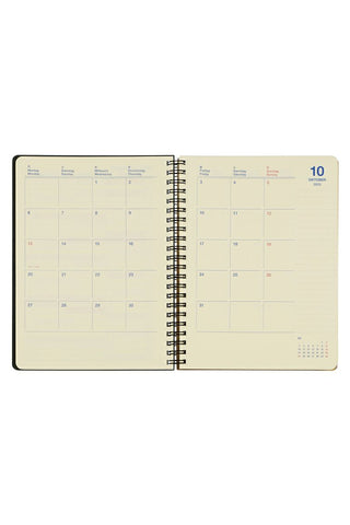 Open spiral-bound planner with calendar pages on a white background