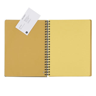 Open yellow notebook with a spiral binding on a white background. Plastic sheet pages holding business card