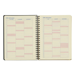 Open spiral-bound planner with monthly layout on beige paper