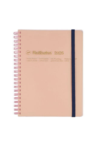 Light pink planner with a navy strap on a white background and gold text detail