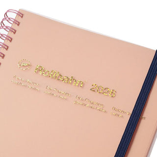 Pink planner with gold text on a white background