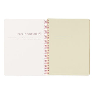 Notebook with cream pages and rose gold spiral binding on a white background