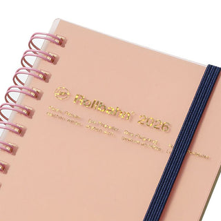 Pink planner with gold text and a navy  band on a white background