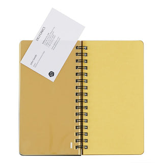 Yellow pages in a spiral-bound notebook with a business card inside a plastic sleeve