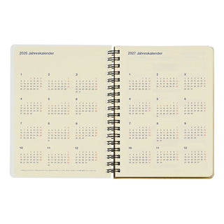Open spiral-bound calendar notebook showing pages for 2026 and 2027 on a white background.