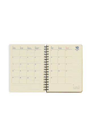 Open spiral-bound planner with monthly calendar on a white background