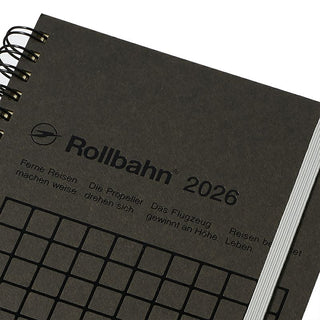 Black notebook with 'Rollbahn' branding and text on a white background