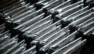 notebooks in a row with silver packaging with white sticker that reads 'rollbahn'