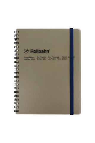 spiral notebook with clear gray cover, navy rubber band and black spiral rings that reads 'rollbahn'