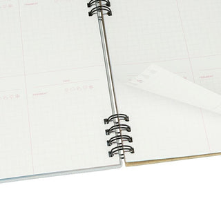 Close-up of a spiral-bound notebook with white pages on a white background