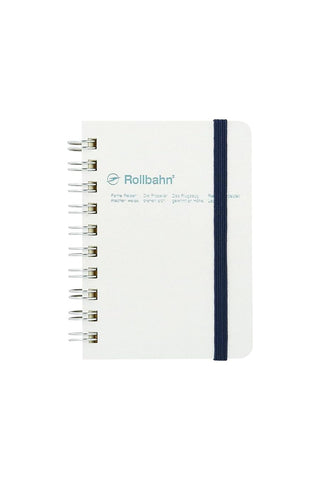 spiral notebook with metallic pearl white cover, black rubber band and silver spiral rings that reads 'rollbahn'