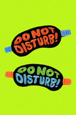 Two 'Do Not Disturb' eye masks on a green background