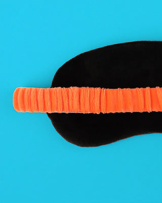 Back of sleep mask with an orange band on a blue background