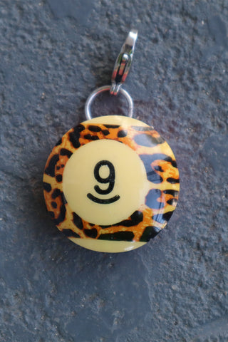 Leopard print pendant with number 9 on a dark background