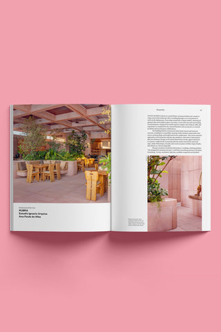 Open magazine showing interior design images and text on a pink background