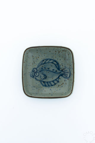 Square ceramic plate with blue flounder design on a white background