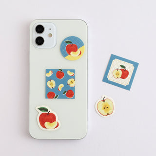 Phone with apple-themed stickers on a light gray background